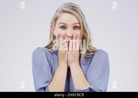 Realmente non so che cosa dire. Studio ritratto di una giovane donna attraente guardando scioccato su uno sfondo grigio. Foto Stock