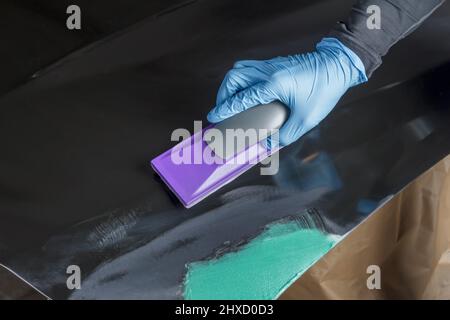 Levigare le parti della carrozzeria dell'auto con una levigatrice manuale prima della verniciatura. Foto Stock