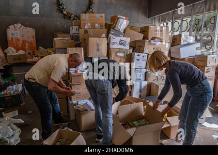 Volontari ucraini sono visti nella Parrocchia di Santa Monica collaborando alla raccolta di materiale di emergenza per aiutare i rifugiati al confine con la Polonia. I volontari ucraini residenti a Barcellona svolgono diverse iniziative di sostegno per i loro compatrioti dopo l'occupazione russa dello stato ucraino. Foto Stock