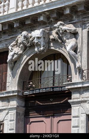 Figure storiche di pietra sopra la porta ad arco nel quartiere Santa Croce a Venezia, Italia Foto Stock