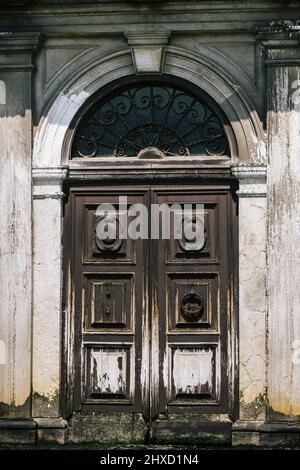 Porta in legno veneziano con intemperie direttamente sul Canal Grande di Venezia Foto Stock