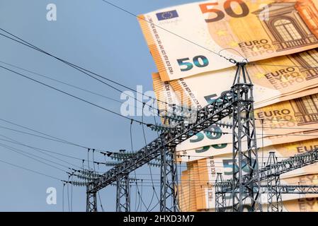 Torre con cavi elettrici ad alta tensione con banconote in euro in background, costoso prezzo crisi concetto di energia Foto Stock