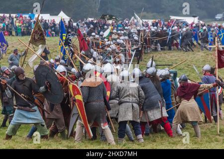 Inghilterra, East Sussex, Battle, The Annual Battle of Hastings 1066 Re-enactment Festival, partecipanti vestiti in Medieval Armor Fighting a Battle Foto Stock