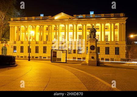 La facciata anteriore dell'edificio una biblioteca pubblica e la statua storica di notte a Poznan Foto Stock