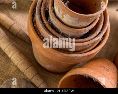 Primo piano di una pila coperta di ciottoli di pentole di terracotta su un sacco hessiano. Foto Stock