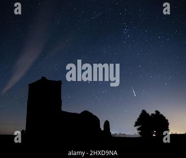 Meteore nel cielo notturno sopra Knowlton Church, Cranborne, Dorset, Inghilterra, Regno Unito, Durante le docce Perseid Meteor annuali (agosto 2021) Foto Stock