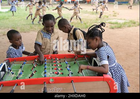 COSTA D'AVORIO, Abidjan, scuola cattolica, bambini giocano a calcio balilla / ELFENBEINKUESTE, Abidjan, Stadtteil Koumassi-Remblais, Foyer Marie Dominique von den Soeurs Salesiennes de Don Bosco / Filles Marie Auxiliatrice (FMA), Schule für Kinder, Kinder spielen auf Schulhof Tischfussball Foto Stock