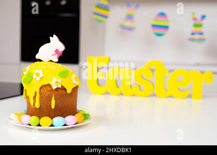 Torta di Pasqua con un coniglio e uova dipinte sul tavolo. Festa religiosa. Foto Stock