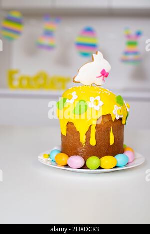 Torta di Pasqua con un coniglio e uova dipinte sul tavolo. Festa religiosa Foto Stock