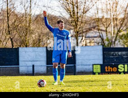 Il Kendal Town FC ha ospitato il Warrington Rylands 1906 FC a Parkside Road, Kendal, per una partita non di campionato. Andrew Scarisbrick riceve segnali per il suo calcio libero Foto Stock