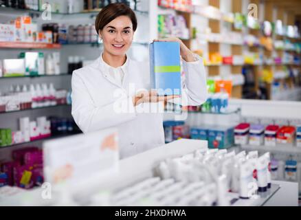 Farmacista femminile che suggerisce prodotti per la cura del corpo utili Foto Stock