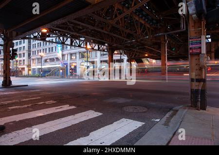 Chicago USA - Agosto 30 2015: Scena stradale da sotto il sistema ferroviario in testa al crepuscolo con flussi di luce da veicoli di passaggio. Foto Stock