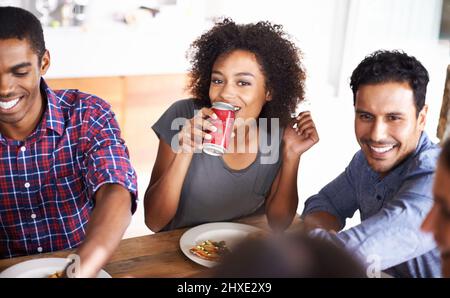 Lasciate che i buoni tempi rotolino. Un'immagine ritagliata di un gruppo di amici che si divertono con la pizza. Foto Stock