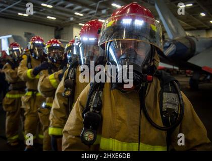 220218-N-SY758-1049 OCEANO ATLANTICO (DAL 18, 2022) marinai assegnati a USS George H.W. Bush (CVN 77) riassemblare dopo aver combattuto un incendio simulato nella baia di hangar durante il Tailored Ship’s Training Availability/Final Evaluation Problem (TSTA/FEP), 18 febbraio 2022. TSTA/FEP è un'evoluzione della formazione multifase progettata per dare all'equipaggio una solida base di competenza operativa a livello di unità e per migliorare la capacità della nave di autoaddestrarsi. George H.W. Bush fornisce all'autorità di comando nazionale capacità di lotta contro la guerra flessibile e personalizzabile attraverso il gruppo di sciopero del vettore che mantiene gli stabili marittimi Foto Stock