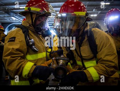 220218-N-SY758-1041 OCEANO ATLANTICO (DAL 18, 2022) marinai assegnati a USS George H.W. Bush (CVN 77) combattete un incendio simulato nella baia di Hangar durante il Tailored Ship’s Training Availability/Final Evaluation Problem (TSTA/FEP), 18 febbraio 2022. TSTA/FEP è un'evoluzione della formazione multifase progettata per dare all'equipaggio una solida base di competenza operativa a livello di unità e per migliorare la capacità della nave di autoaddestrarsi. George H.W. Bush fornisce all'autorità di comando nazionale capacità di lotta contro la guerra flessibile e personalizzabile attraverso il gruppo di sciopero del vettore che mantiene la stabilità e la sicurezza marittima in o Foto Stock