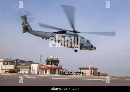 YOKOSUKA, Giappone (10 marzo 2022) un MH-60R Sea Hawk, attaccato ai “Saberhawks” di Helicopter Maritime Strike Squadron (HSM) 77, parte Commander, Fleet Activities Yokosuka con un MK 54 Lightweight Torpedo durante un esercizio di addestramento. Il modello MK 54 è un siluro da training inerte progettato per essere recuperato e riutilizzato per gli esercizi di allenamento. HSM-77 è collegato a Commander, Task Force 70 e Forward-schierato alla flotta degli Stati Uniti 7th area di responsabilità a sostegno di un libero e aperto Indo-Pacific. (STATI UNITI Foto Navy di Mass Communication Specialist 2nd Classe Erica Bechard) Foto Stock