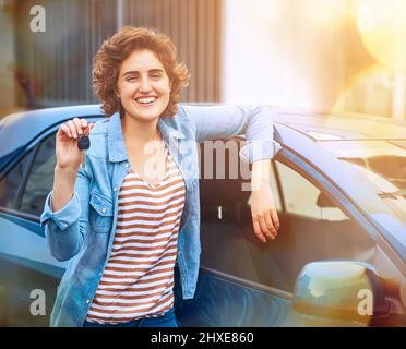 Im ufficialmente un proprietario di automobile. Scatto di una giovane donna felice che tiene le chiavi di una nuova auto. Foto Stock