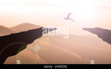 Giovane uomo che salpano in Mountain Sunset tra due scogliere. Business Gola e concetto di ambizione Foto Stock