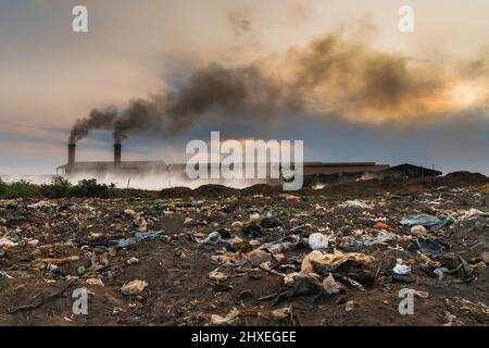 Spazzatura di fronte a Smokestack Factory, industria e concetto di inquinamento Foto Stock