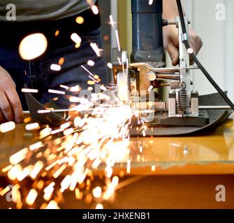 l'uomo taglia metallo e scintille Foto Stock