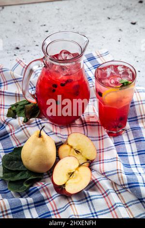 Limonata di frutta e bacche fresche in una caraffa e un bicchiere Foto Stock