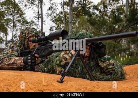 BAISE, CINA - 10 MARZO 2022 - soldati di forze operative speciali prendono parte alla formazione di combattimento sul campo nella città di Baise, Guangxi Zhuang A della Cina meridionale Foto Stock