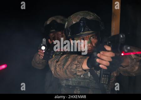 BAISE, CINA - 10 MARZO 2022 - i soldati delle forze speciali di operazioni prendono parte ad un addestramento notturno di combattimento nella città di Baise, Guangxi Zhuang della Cina meridionale Foto Stock