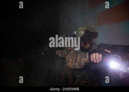 BAISE, CINA - 10 MARZO 2022 - i soldati delle forze speciali di operazioni prendono parte ad un addestramento notturno di combattimento nella città di Baise, Guangxi Zhuang della Cina meridionale Foto Stock