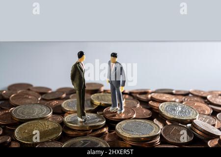 alcuni modelli in miniatura su una superficie ricoperta di monete in euro Foto Stock