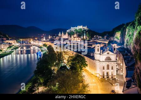 La vista dall'alto è fantastica in una città serale che splende dalle luci. Scena drammatica. Posizione luogo famoso (patrimonio dell'umanità dell'unesco) Festung Hohensalzburg, Salz Foto Stock