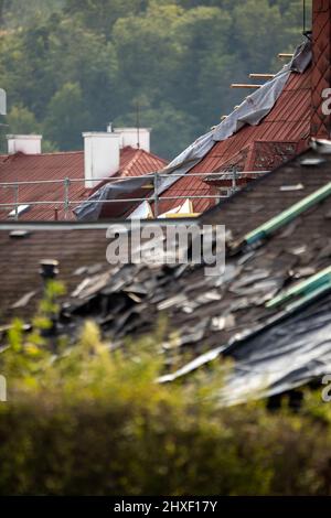 Tetto danneggiato da tempesta, tegole distrutte, danni costosi che richiedono una riparazione immediata Foto Stock