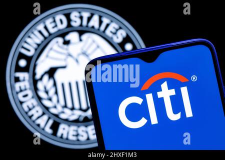 Smartphone con logo Citigroup sullo sfondo del simbolo della Federal Reserve Foto Stock