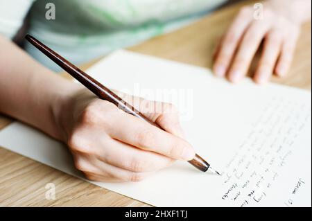 Scrivere una lettera ad un amico. Mano che tiene una penna stilografica. Foto Stock