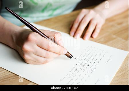 Scrivere una lettera ad un amico. Mano che tiene una penna stilografica. Foto Stock