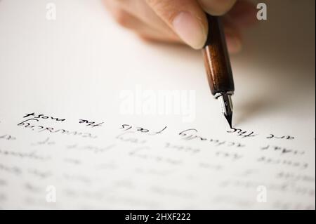 Scrivere una lettera ad un amico. Mano che tiene una penna stilografica. Foto Stock