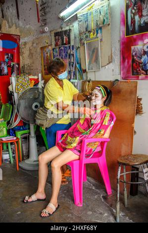 Chinatown, Bangkok – Nov, 14, 2020: Antico metodo cinese per rimuovere i capelli del viso utilizzando due fili per stringere e tirare. Foto Stock