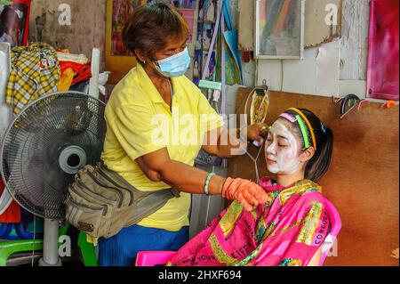 Chinatown, Bangkok – Nov, 14, 2020: Antico metodo cinese per rimuovere i capelli del viso utilizzando due fili per stringere e tirare. Foto Stock