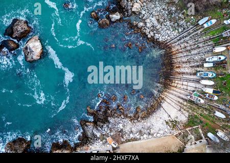 Vista aerea dall'alto sulla piccola baia e molo con barche da pesca sulla riva Foto Stock