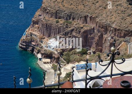 La vista era fantastica dalla terrazza del ristorante con un tavolo e sedie sul vecchio porto e sul Mar Egeo di Santorini Foto Stock