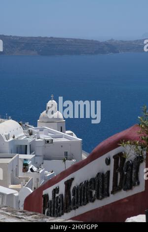 Santorini, Grecia - 10 maggio 2021 - gradini che conducono ad un bar con una splendida vista sul villaggio imbiancato di Fira e sul Mar Egeo di Santorini Foto Stock