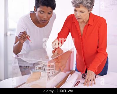 Due teste sono migliori di una. Foto di due architetti femminili che discutono di un modello architettonico. Foto Stock
