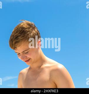 Carino il ragazzo felice dopo una nuotata al sunny beach Foto Stock