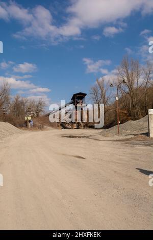 Una vecchia cava di ghiaia. Attrezzature per estrazione mineraria e cava. Granito pietra ghiaia miniera open pit. Foto Stock