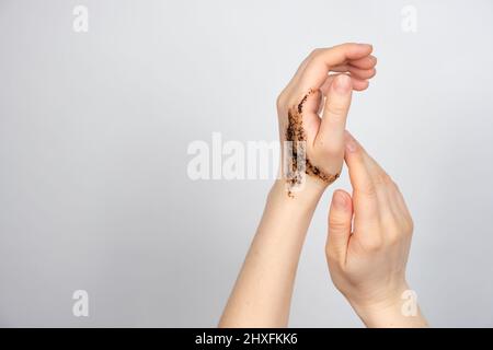 Scrub di caffè sulle mani delle donne, cura della pelle del corpo e delle mani, scrubbing e pilling, un posto per il testo Foto Stock