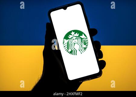 11 marzo 2022, Barcellona, Catalogna: In questa illustrazione di foto un logo Starbucks visto su uno smartphone con una bandiera dell'Ucraina sullo sfondo. (Credit Image: © Thiago Prudencio/DAX via ZUMA Press Wire) Foto Stock