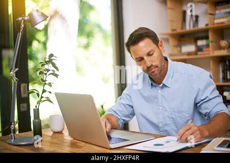 Assicurarsi che i numeri si aggiungano. Scatto di un giovane che lavora da casa. Foto Stock