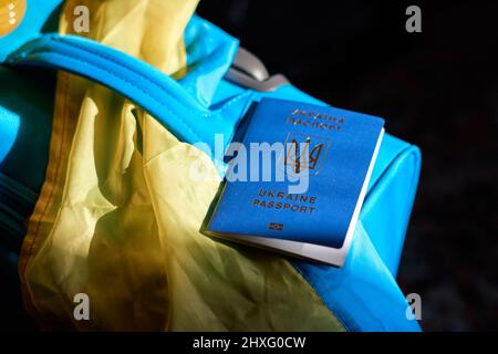 Bagaglio per rifugiati ucraini con passaporto e bandiera giallo-blu. Evacuazione di civili, famiglie dall'Ucraina che attraversano la frontiera. Arrestare la guerra, supportare U. Foto Stock