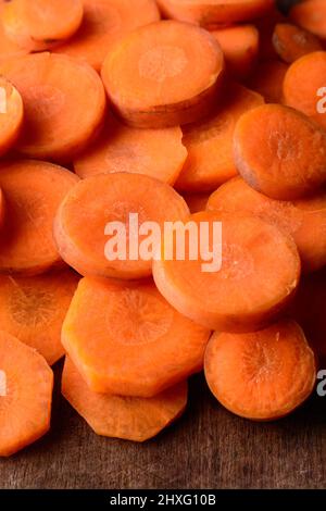 mucchio di fette di carota, vibrante arancio di radice vegetale tritato, preso in profondità di campo poco profonda, primo piano Foto Stock