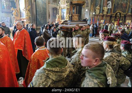 I militari ucraini trasportano una bara di uno dei tre soldati ucraini uccisi durante le battaglie con le truppe russe. Una cerimonia funeraria si è svolta presso la chiesa della Garrisone di San Pietro e Paolo per rendere omaggio ai tre soldati: Dmitro Kotenko, Kirill Moroz e Vasil Vyshivany, che sono morti vicino a Kherson durante l'aggressione russa in Ucraina. Foto Stock