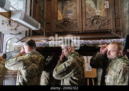 I militari ucraini trasportano una bara di uno dei tre soldati ucraini uccisi durante le battaglie con le truppe russe. Una cerimonia funeraria si è svolta presso la chiesa della Garrisone di San Pietro e Paolo per rendere omaggio ai tre soldati: Dmitro Kotenko, Kirill Moroz e Vasil Vyshivany, che sono morti vicino a Kherson durante l'aggressione russa in Ucraina. Foto Stock